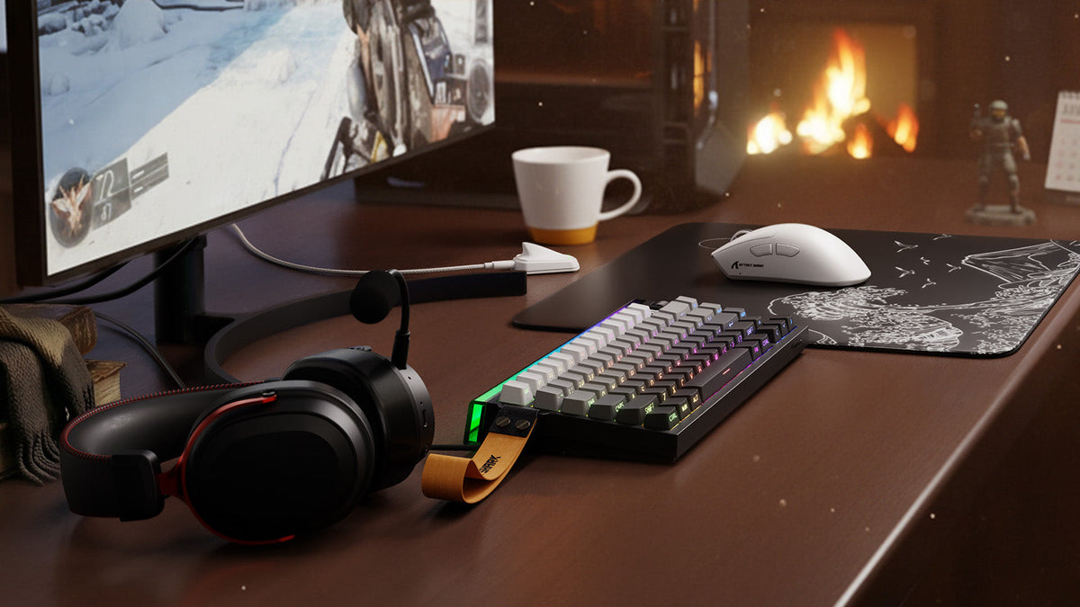 A cozy gaming desk setup featuring a compact mechanical keyboard with a yellow strap, a white wireless mouse on a graphic mousepad, and a black headset with red accents